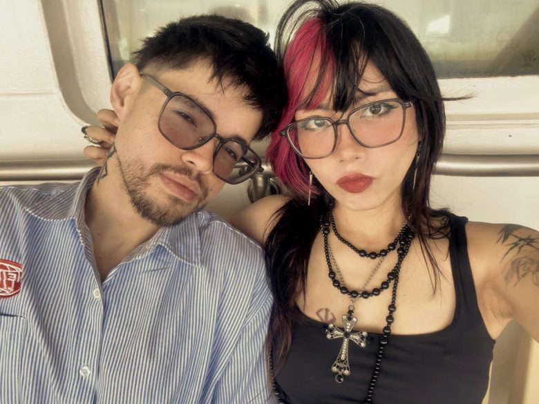 Marc-Kevin and Florence leaning together on a boat, both wearing glasses.